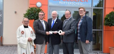 Fünf Personen vor dem Gemeindehaus Eifelblick Reifferscheid, vier halten einen großen Schlüssel. Anlass zur Eröffnung des Hauses in 2017