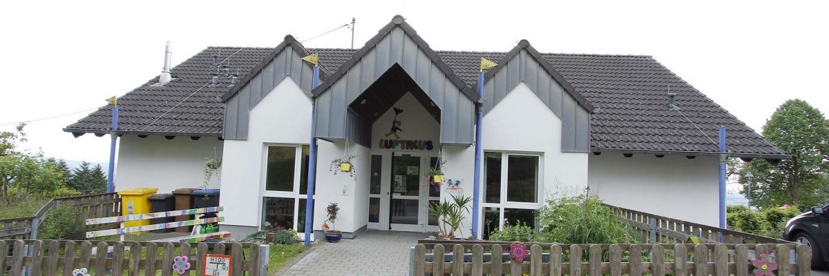 Kindergarten Luftikus Reifferscheid Kindergarten Luftikus Gebäudeansicht mit dem Eingangsbereich umgeben mit einem Gartenzaun aus Holz dekoriert mit bunten Holzblüten